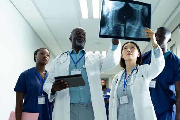 Four health professionals reviewing x-rays.